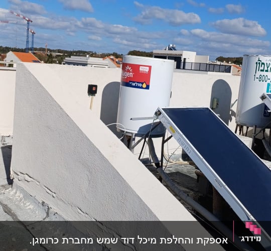 דוד שמש וקולטים על גג תחת שמיים כחולים